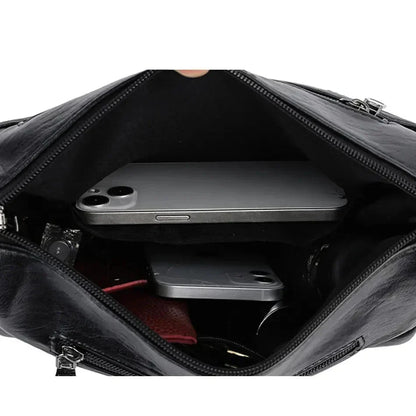 Black leather crossbody bag interior with open main compartment and phone sleeve